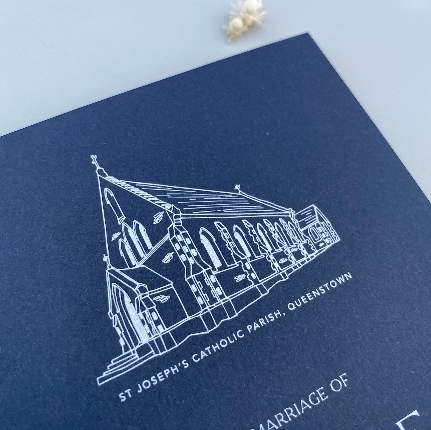 Navy blue card with white line drawing of a church and text on a light blue background