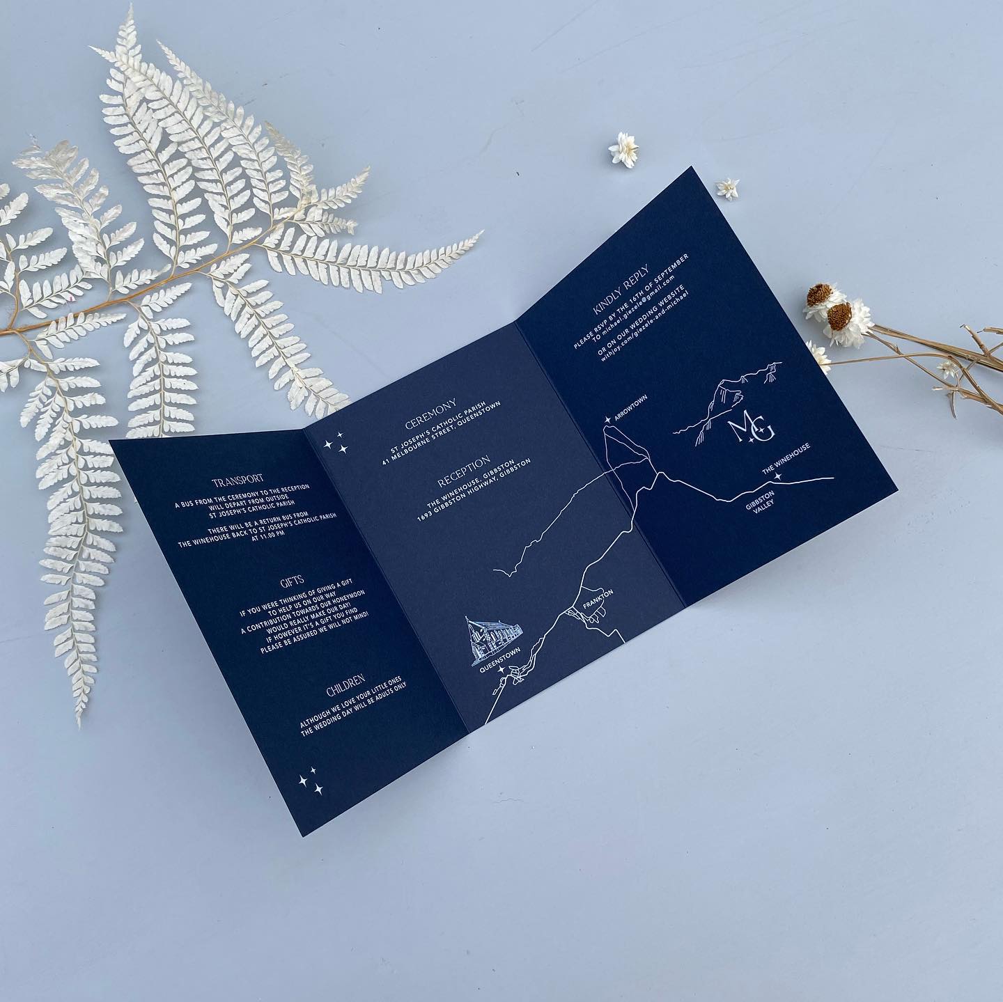 Open blue tri fold invitation with star constellation illustrations and custom map