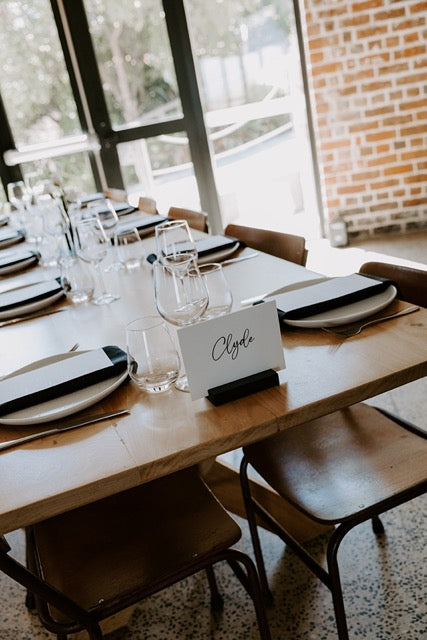 Table name on a wedding table in a modern interior setting at Lochend Woolshed
