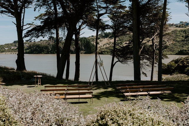 Outdoor wedding at Lochend Woolshed with triangle arch and floral arrangements 