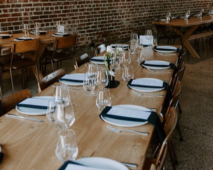 Dining area with wooden tables, chairs, at Lochend Woolshed