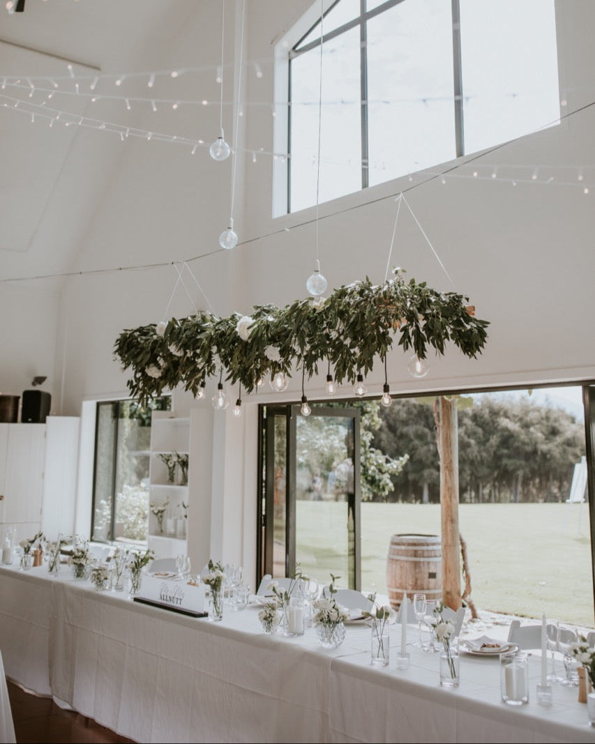 Elegant indoor setting with a long table, decorative greenery, and string lights at the Lookout Lodge Wanaka