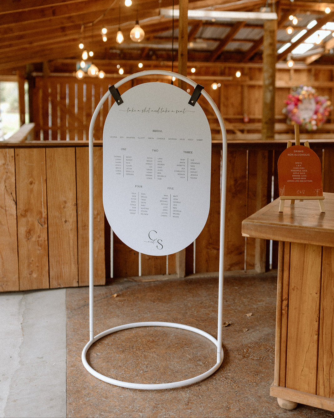 Custom white oval seating plan set in the rustic wedding venue Glendhu Station