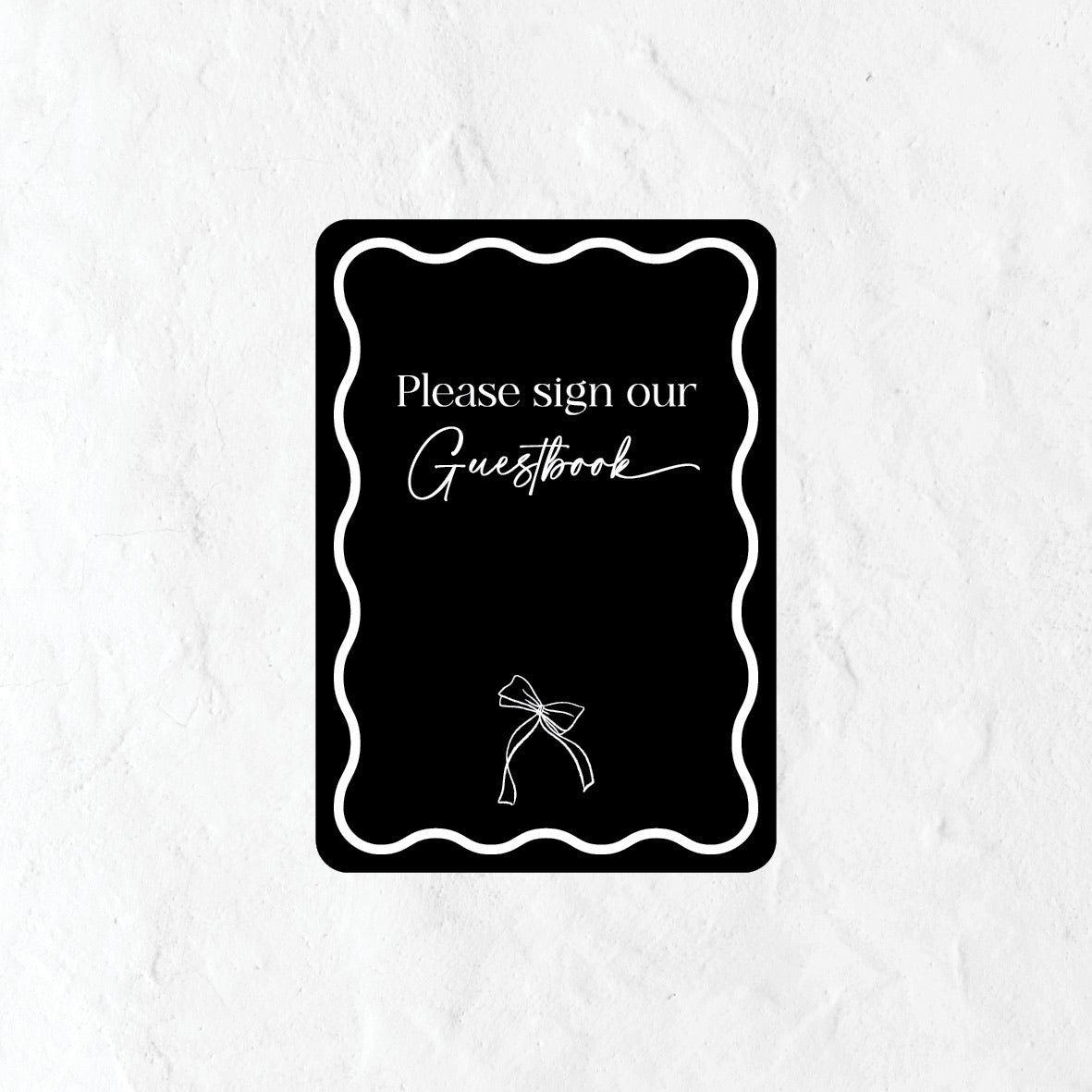 Black please sign our guestbook sign and a bow graphic on a white background 