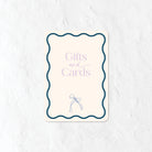 Gifts and Cards sign in a pastel purple and blue palette and a bow illustration 
