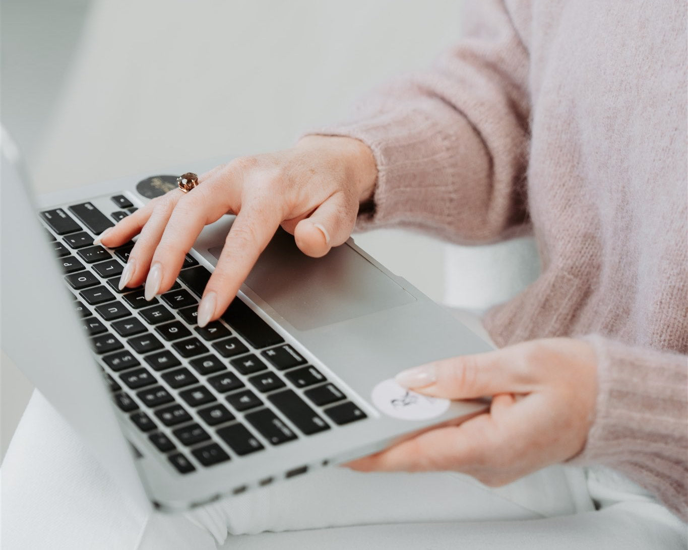 Person using a laptop with hands on the keyboard and mouse
