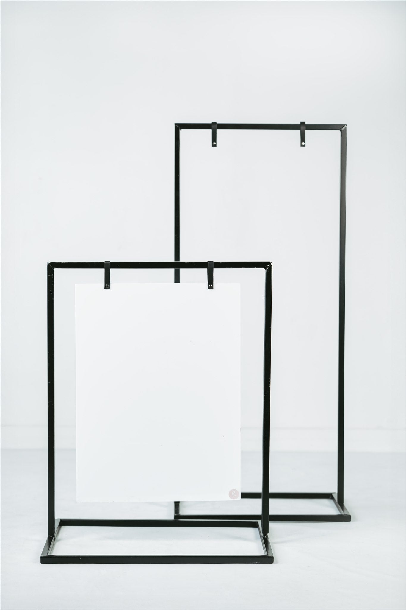 Two black metal signage stands on a white background